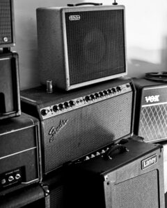 many different guitar amps stacked on top of each other.